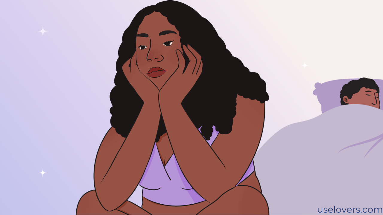 no fundo há um homem dormindo e na frente tem uma mulher sentada na cama segurando a cabeça com as mãos com cara de emburrada ou entendiada